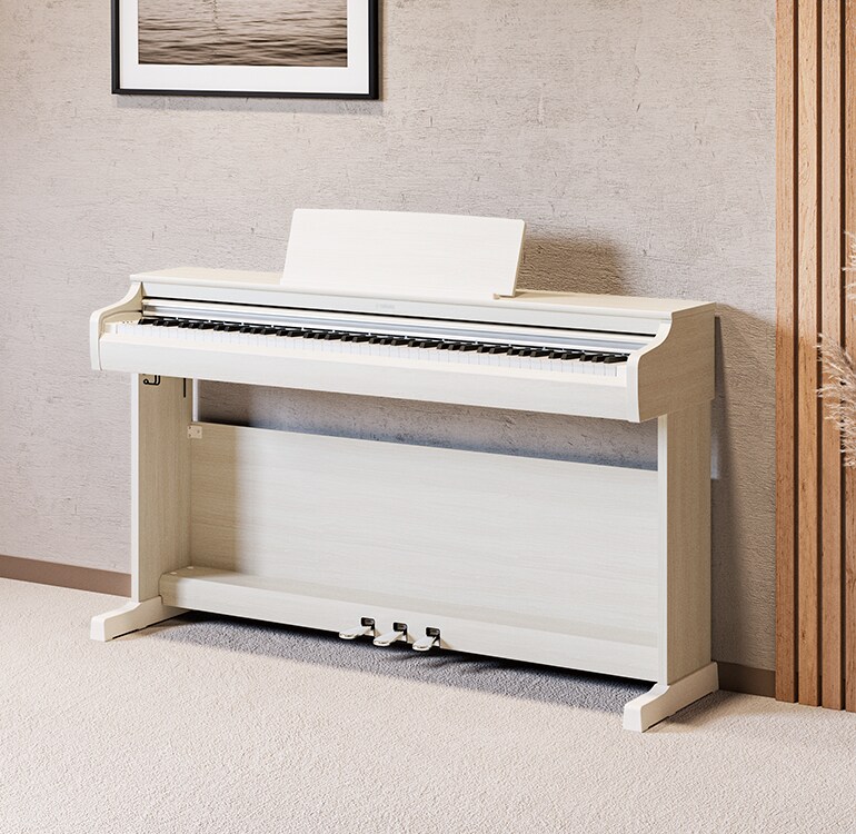 Una sala de estar que cuenta con un piano ARIUS color abedul blanco con plantas de interior y un sofá, armoniosamente integrado con la decoración
