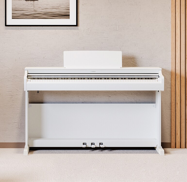 Una sala de estar que cuenta con un piano ARIUS color blanco con plantas de interior y un sofá, armoniosamente integrado con la decoración