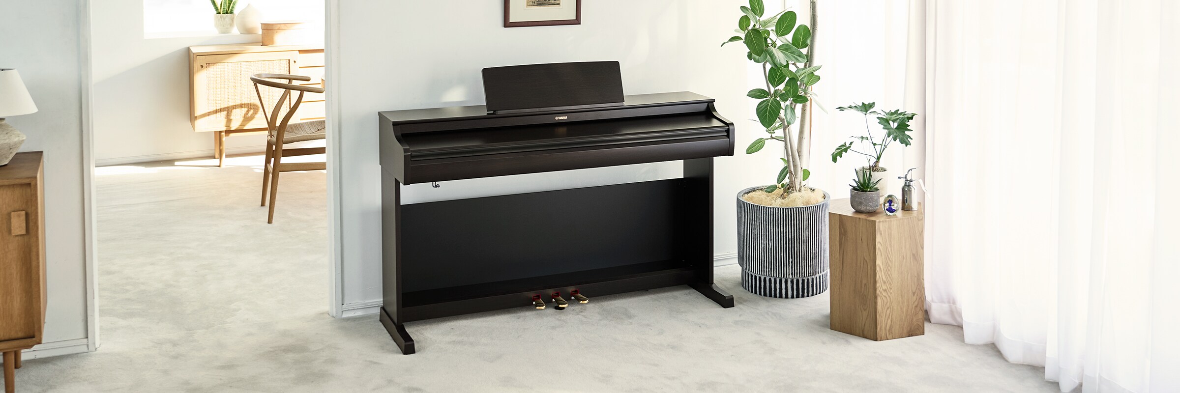 Un piano ARIUS en una sala de estar con la tapa cerrada, integrándose con la decoración