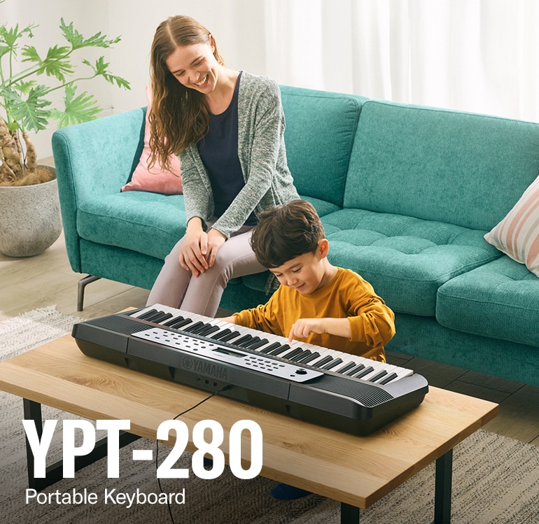 Parent and child happily playing the YPT-280 on the table