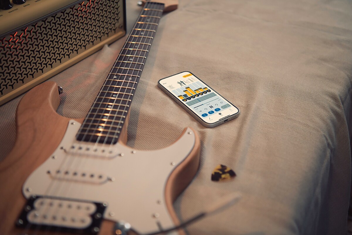 La app de práctica musical Extrack junto a una guitarra eléctrica y un amplificador