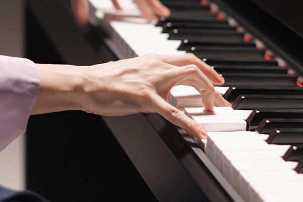 Manos tocando el teclado Graded Hammer Standard (GHS)